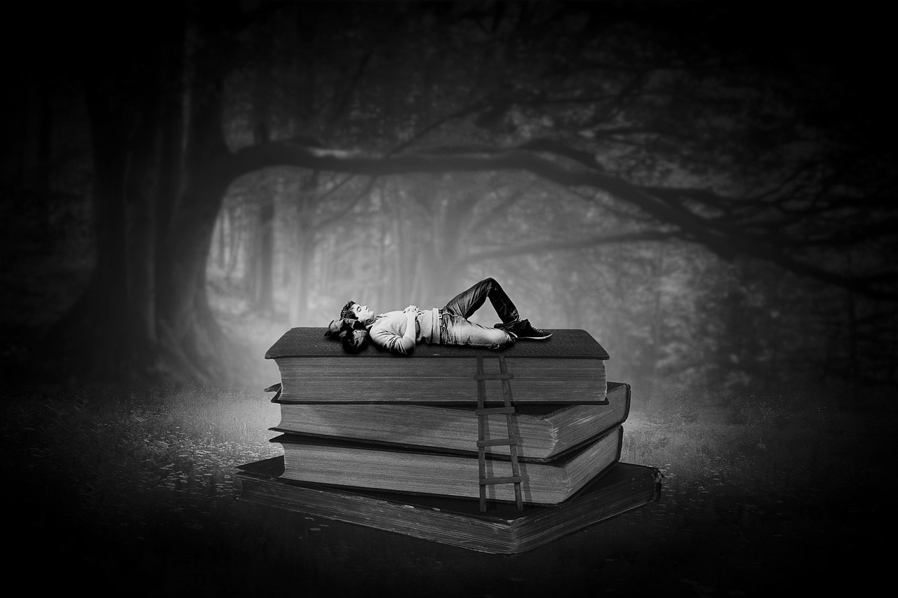 immagine onirica di un ragazzo sdraiato sopra tre libri giganti in un bosco