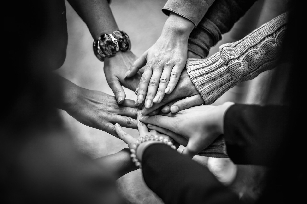 mani di donne e uomini che si uniscono in un cerchio